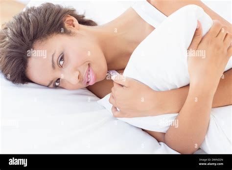 Smiling Pretty Brunette Lying On Bed Hugging Pillow Stock Photo Alamy