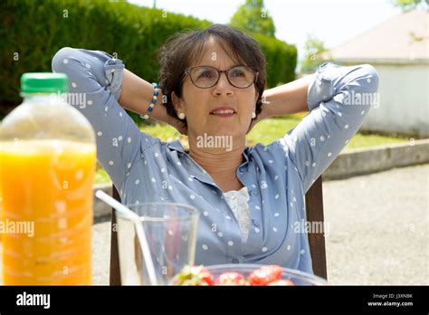 A Senior Brunette Woman Relaxes In Her Garden Stock Photo Alamy