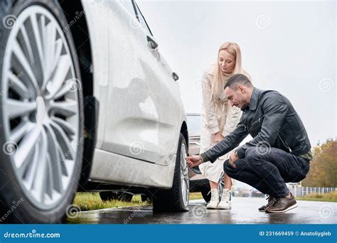 Young Man Helping Charming Woman To Fix Car Wheel Stock Image Image