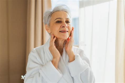 Mature Adult Old Woman Applying Nourishing Anti Age Face Cream Doing Daily Beauty Routine