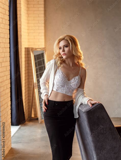 The Blonde Girl Is Dressed In Office Clothes She Unbuttons Her Shirt And Demonstrates Beautiful