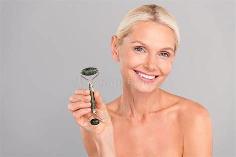 Photo Of Adorable Sweet Senior Lady Nude Shoulders Showing Quartz Roller Empty Space Isolated