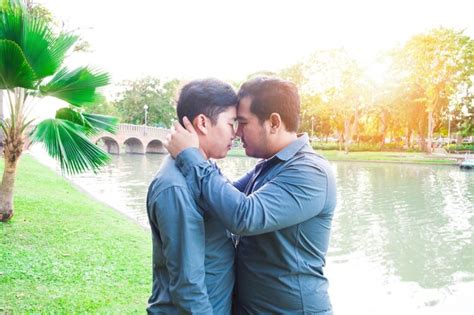 Premium Photo Side View Of Gay Couple Embracing While Standing By River