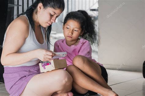 hermosa mujer latina con su hija de piel marrón abriendo el regalo que la niña le dio madre e