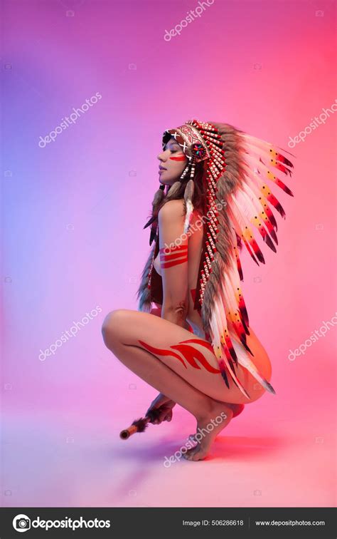 Naked Woman In Native American Costume With Feathers On A Neon Background Stock Photo By