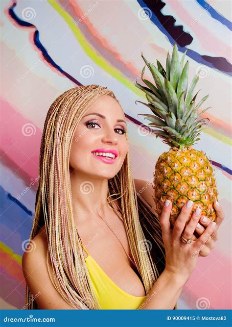 Jeune Mignonne Belle Femme Blonde Mince Avec Les Tresses Africaines Et Avec Des Ananas Dans
