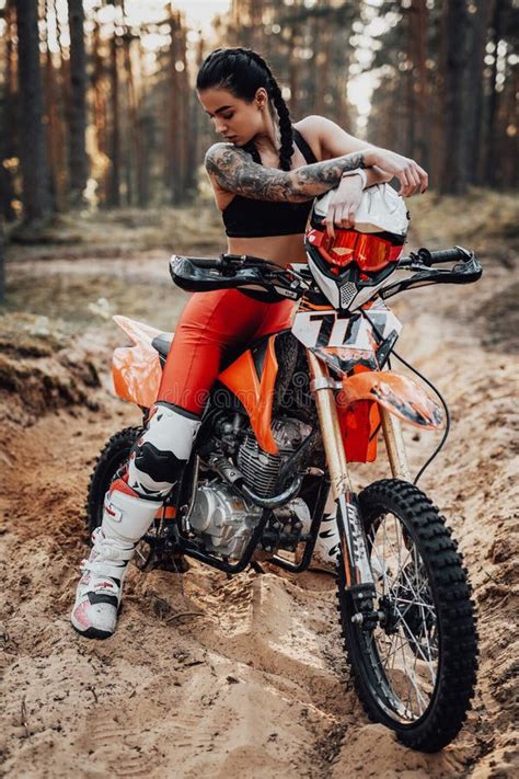 Female Racer Wearing Motocross Outfit With Semi Naked Torso Sitting On Her Bike In The Forest