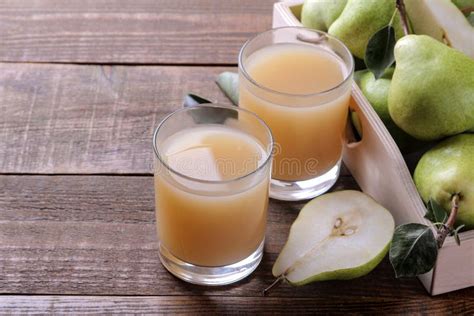 Pear Juice In A Glass With Ripe Pears On A Brown Wooden Table Stock