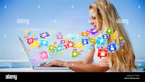 Composite Image Of Pretty Blonde Using Her Laptop At The Beach Stock