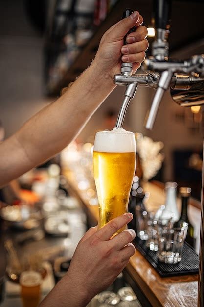 Premium Photo Hands Pouring Draught Beer Into A Glass