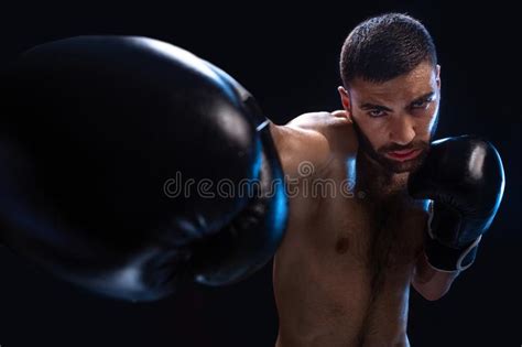 Man Is Hitting An Opponent Focused Fighter With Naked Torso And Boxing Gloves Looking At The