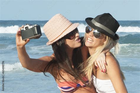 Two Attractive Lesbian Girls On The Beach With Film Camera Stock Photo Adobe Stock
