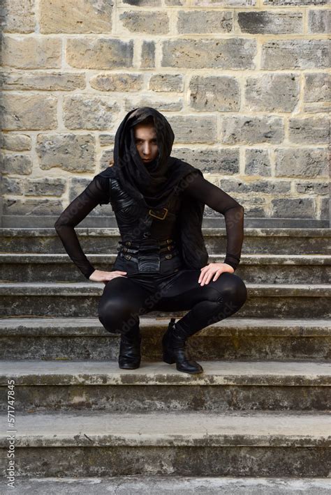 Portrait Of Beautiful Female Model With Blonde Plait Wearing Black Leather Catsuit And Flowing