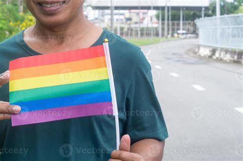 Gay Asi Tico O Tailand S De Pie Y Sonriendo Con La Bandera Del Arco Iris En Sus Manos Para