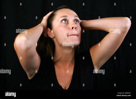 Brunette Woman Holds Back Her Long Hair And Bites Her Lip With An Apprehensive Worried Anxious