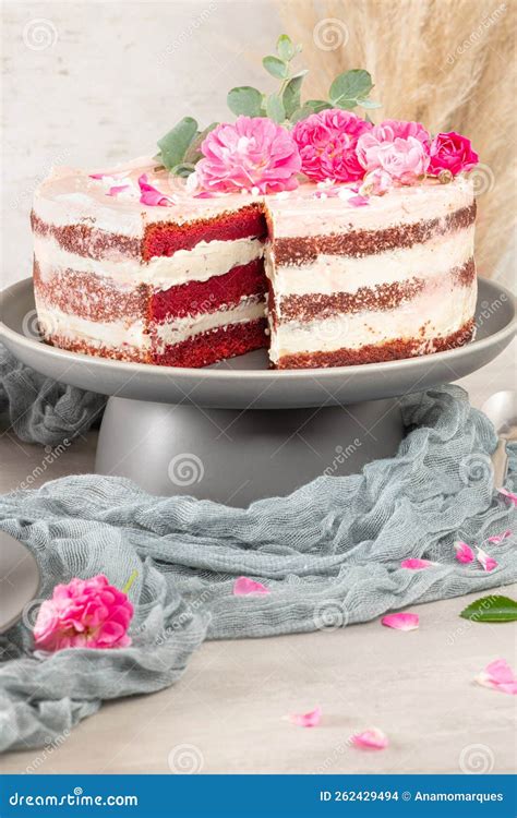 Red Velvet Naked Cake With Fresh Roses And Swiss Buttercream On Kitchen Countertop Stock Photo