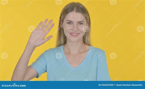 Young Woman Waving Hand To Say Hello On Yellow Background Stock Footage