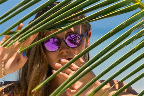 Beautiful Sexy Girl Models In A Bikini On The Sea Shore Of A Tropical Island With Palm Leaf