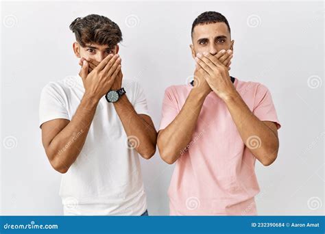 Jeune Couple Gay Debout Sur Fond Isolé Choqué Se Couvrant La Bouche Avec Les Mains Pour L erreur