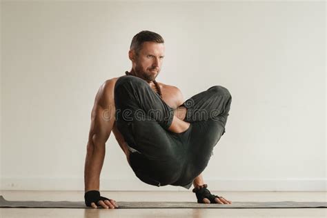 A Man With A Naked Torso Does Yoga Standing On His Hands Indoors Fitness Trainer Stock Image