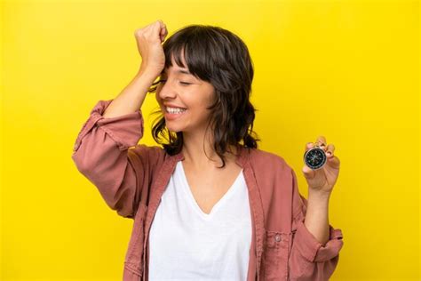 Una Joven Latina Que Sostiene Una Br Jula Aislada En Un Fondo Amarillo Se Ha Dado Cuenta De Algo