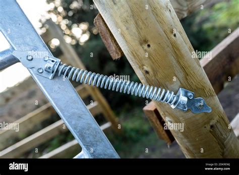 Spring Loaded Galvanised Metal Gate Attached To A Wooden Post Stock