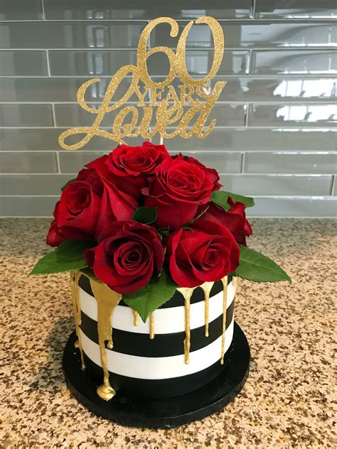 A Beautiful Black And White Striped Fondant Cake With Gold Drip And Red