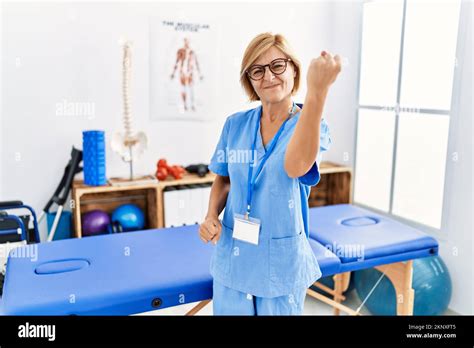 Blonde Frau mittleren Alters in der Schmerzheilungsklinik arbeitet wütend und wahnsinnig