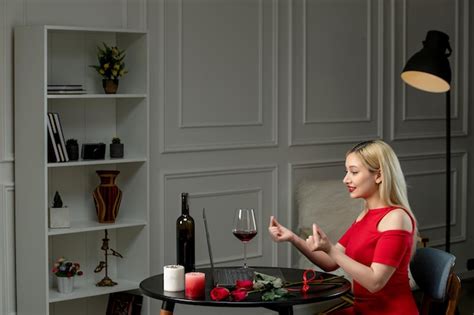 Amour Virtuel Jolie Fille Blonde En Robe Rouge à Distance Avec Du Vin Montrant Le Signe Du Coeur