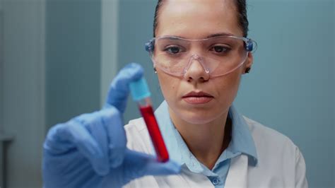 Laboratory scientist holding vacutainer with blood sample in chemical