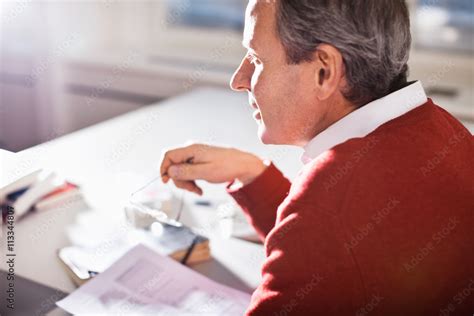 Mature Businessman With Glasses And Documents At Office Desk Stock Photo Adobe Stock