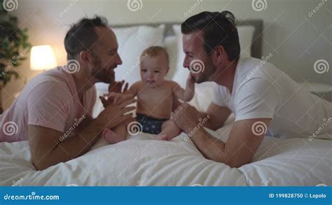 Male Gay Parents Relaxing In Bed With Baby Stock Footage Video Of Sitting Life