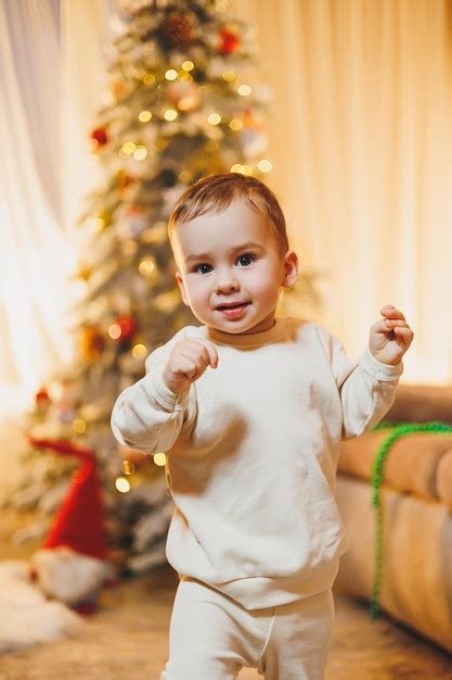 Um menino de 1 ano de idade decora a árvore de Natal Ano Novo Árvore de