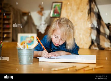 Petite fille blonde allongée sur le sol et le dessin avec des crayons de couleur Photo Stock Alamy