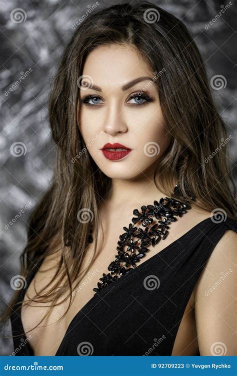 Portrait Of And Seductive Brunette Woman With Red Lipstick In Black Bodysuit On Dark Background