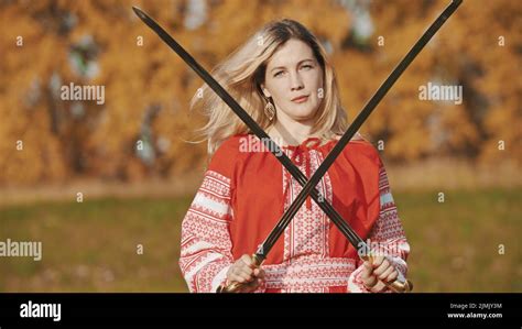 Feisty Blonde Woman In Red National Clothes Standing With Her Swords Crosswise Stock Photo Alamy