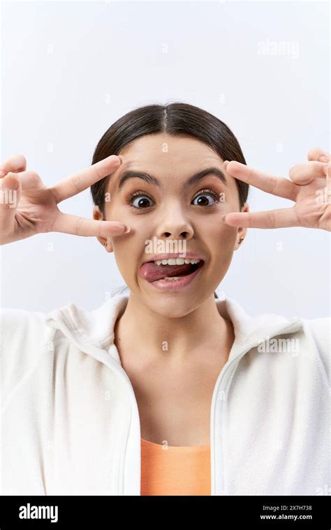 A Brunette Teenage Girl In Sportive Attire Playfully Makes A Funny Face