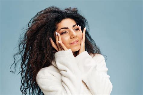 Concepto de crema antienvejecimiento disfruté de una hermosa dama latina rizada en albornoz