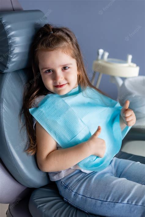 Premium Photo A Little Girl In A Dental Chair With A Blue Towel