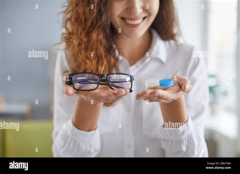 Happy Smiling Young Woman Choosing Between Eyeglasses And Modern