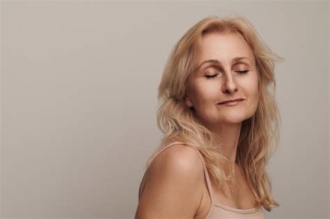 Schöne blonde Frau mittleren Alters mit lächelndem Gesicht und Kameraporträt Elegante reife