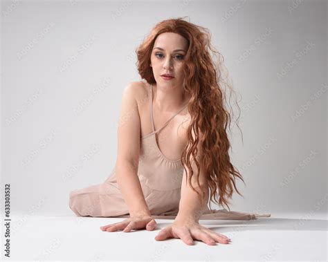 Full Length Portrait Of Beautiful Brunette Model Wearing A Pink Dress Graceful Sitting Pose