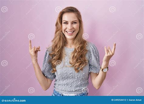 Belle Femme Blonde Debout Sur Fond Rose Crier Avec Une Expression Folle Faire Rock Symbole Avec