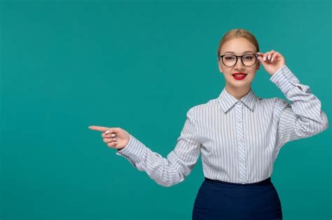 Nette junge blonde frau der geschäftsfrau im bürooutfit und in den gläsern ecke der gläser