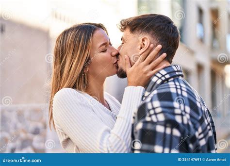 Young Man And Woman Couple Hugging Each Other Kissing At Street Stock