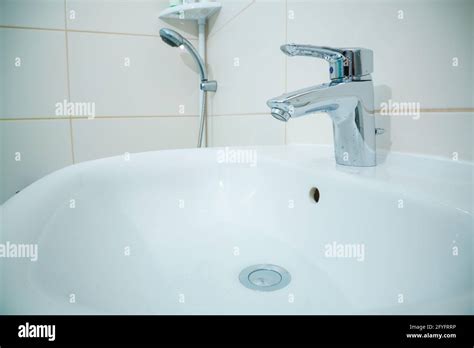 Chromed Metal Faucet For Hot And Cold Water In A Modern Bathroom Stock Photo Alamy