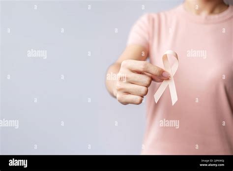 Woman Hand Holding Peach Ribbon For September Uterine Cancer Awareness