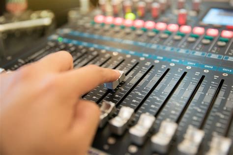 Mano Usando La Consola De Mezcla De Audio Profesional Para Controlar El