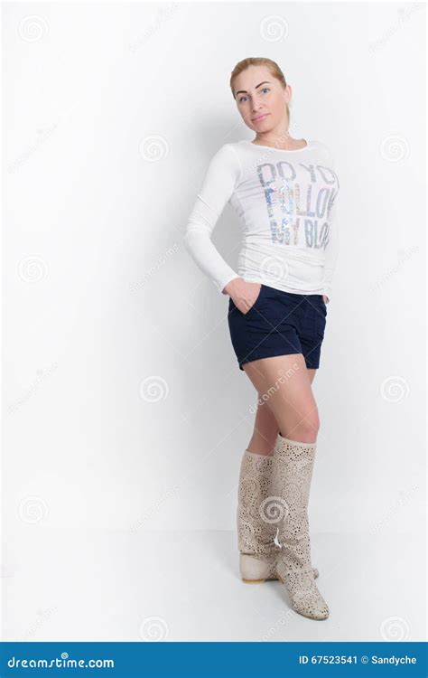 Mooi Jong Blonde In Een Witte Blouse Blauwe Borrels En Het Hoge Laarzen Stellen Stock