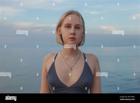 Portrait Of Beautiful Short Haired Blonde Woman Standing On The Background Of Blue Sea And Sky